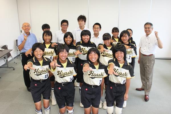 ユニホーム姿の篠山東中学校ソフトボール部女子と制服姿の男子生徒がポーズをとって市長や顧問の先生と記念撮影している写真